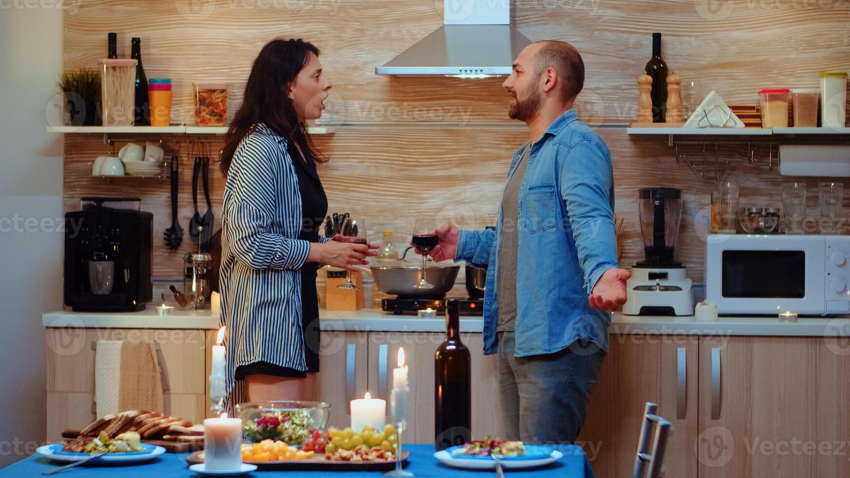Young upset wife fighting with her husband during romantic dinner. Frustrated upset unhappy adult couple with problems having conflicts quarrel problem arguing difficulties in the kitchen photo