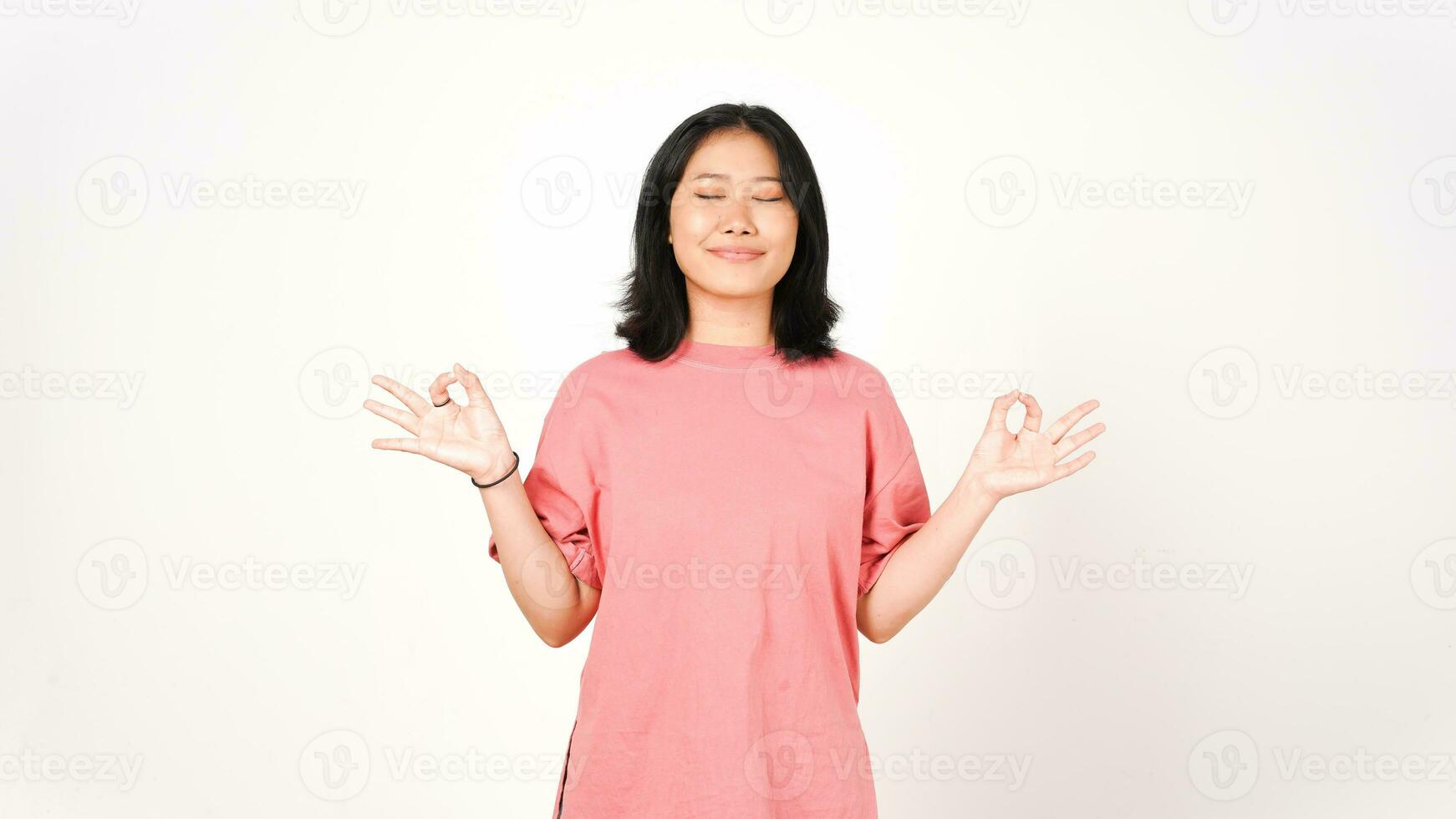 Young Asian woman in pink t-shirt lotus hand position on isolated white background photo