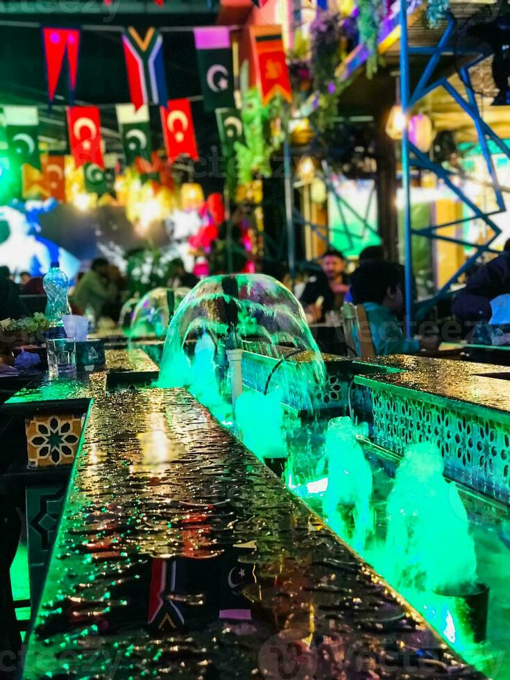 a bar with green lights and a fountain photo