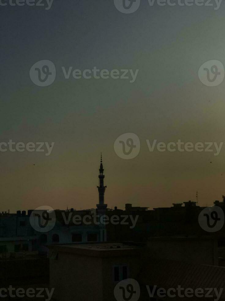 the sun sets over the rooftops of a city photo