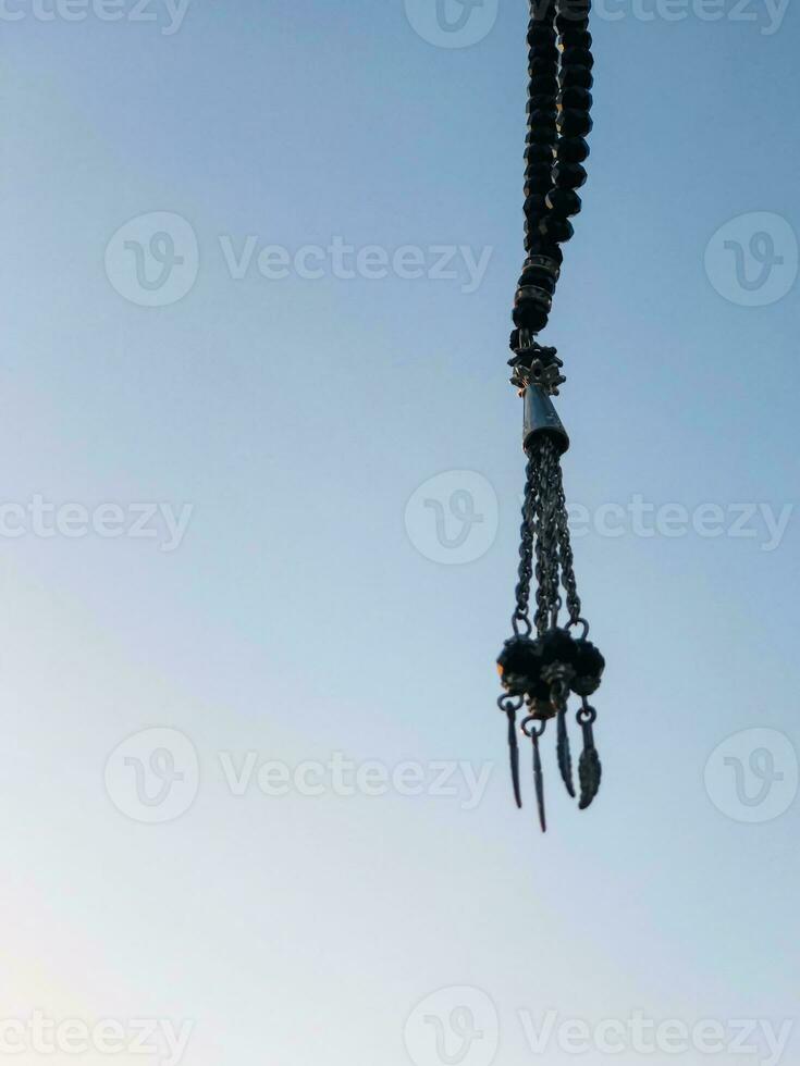 a necklace with red beads hanging from a wall photo