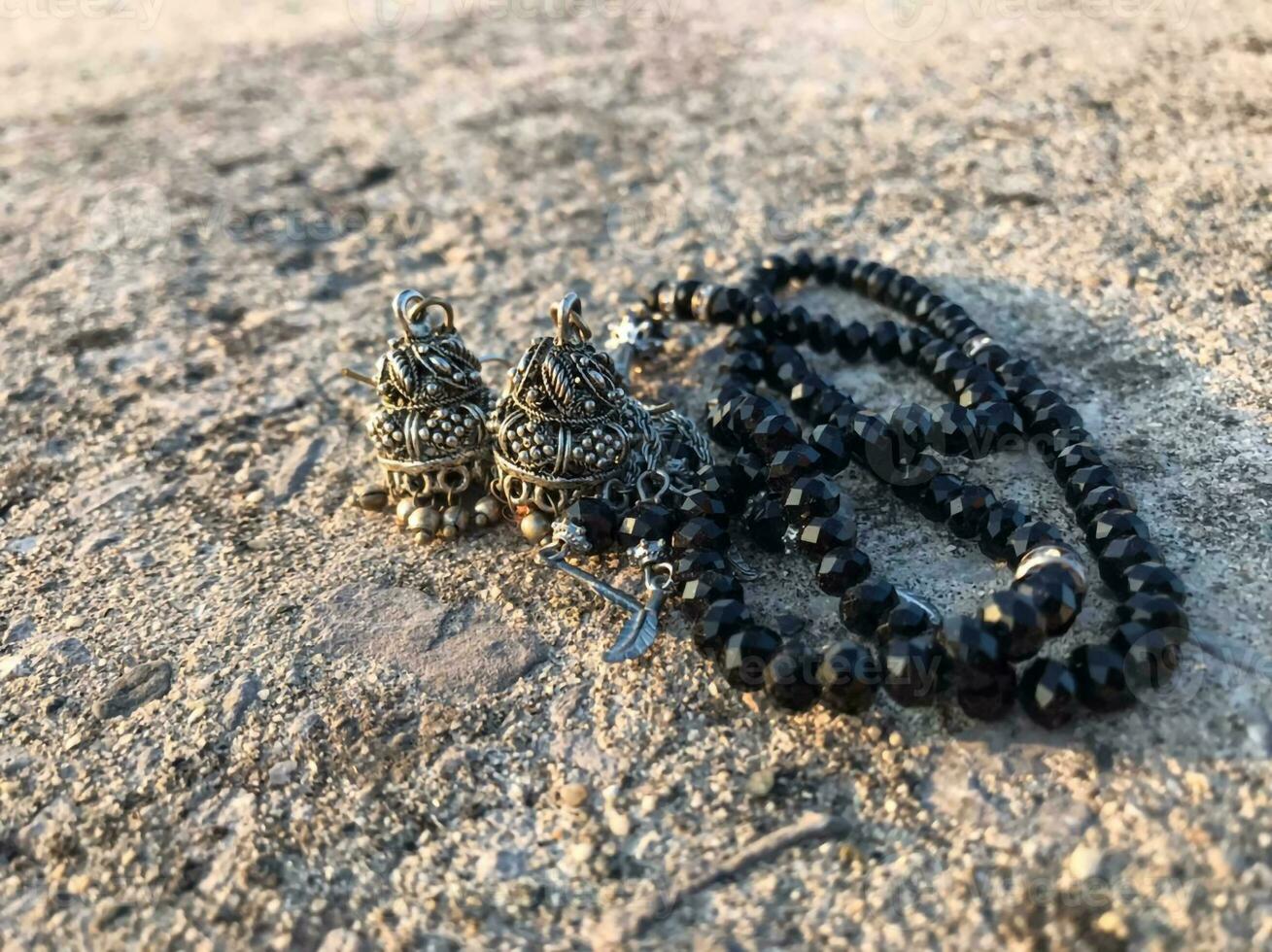 a pair of black beads with a silver charm on it photo