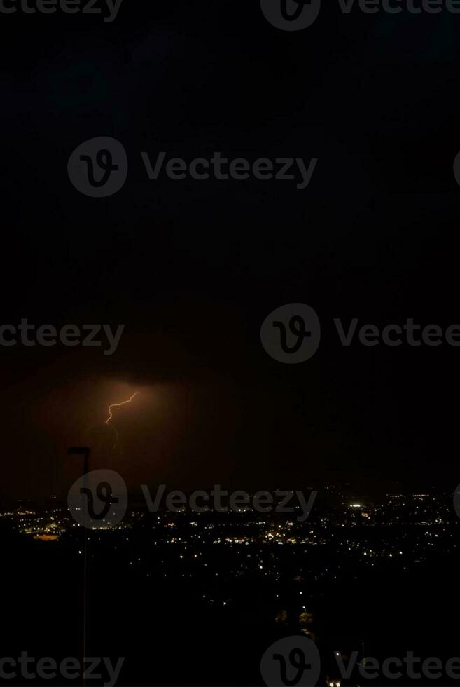 a lightning bolt is seen over a city at night photo