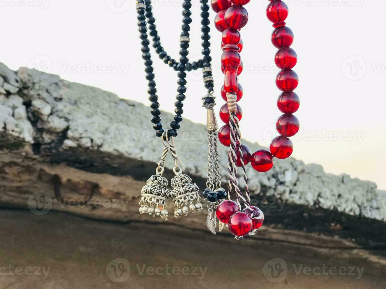 a necklace with red beads hanging from a wall photo