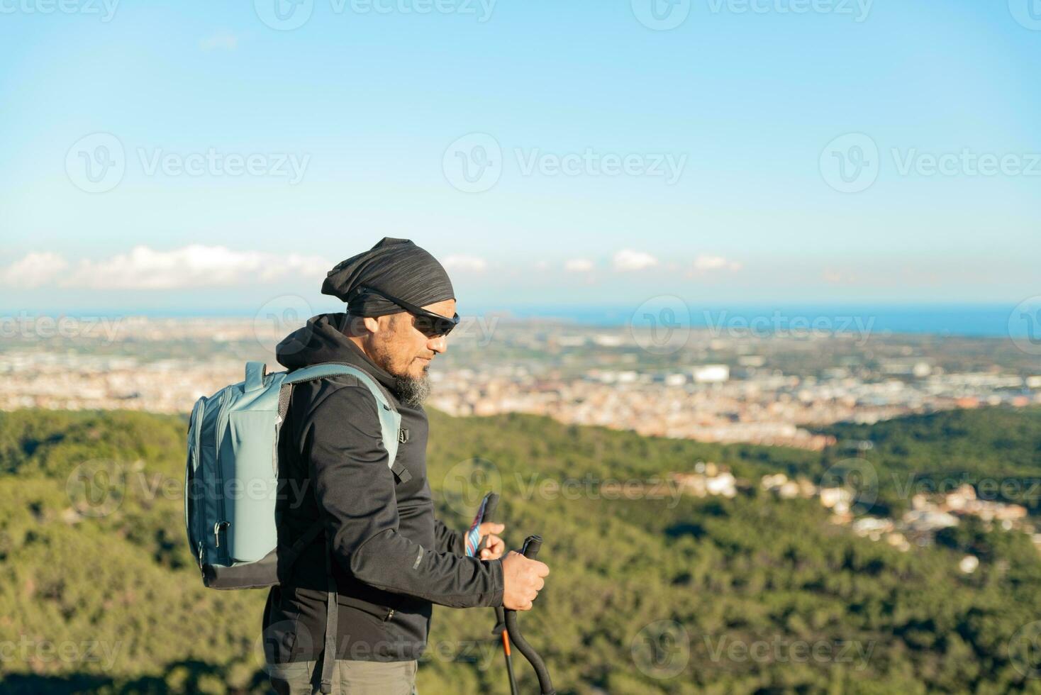 Middle-aged man contemplates the landscapes of the Garraf Natural Park while walking along the trails of a mountain. photo