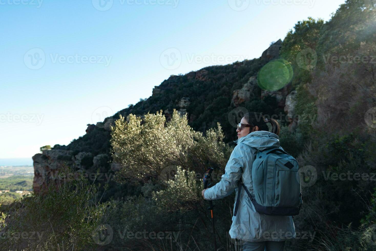 Woman contemplates the landscapes of the Garraf Natural Park while walking the paths of a mountain. photo
