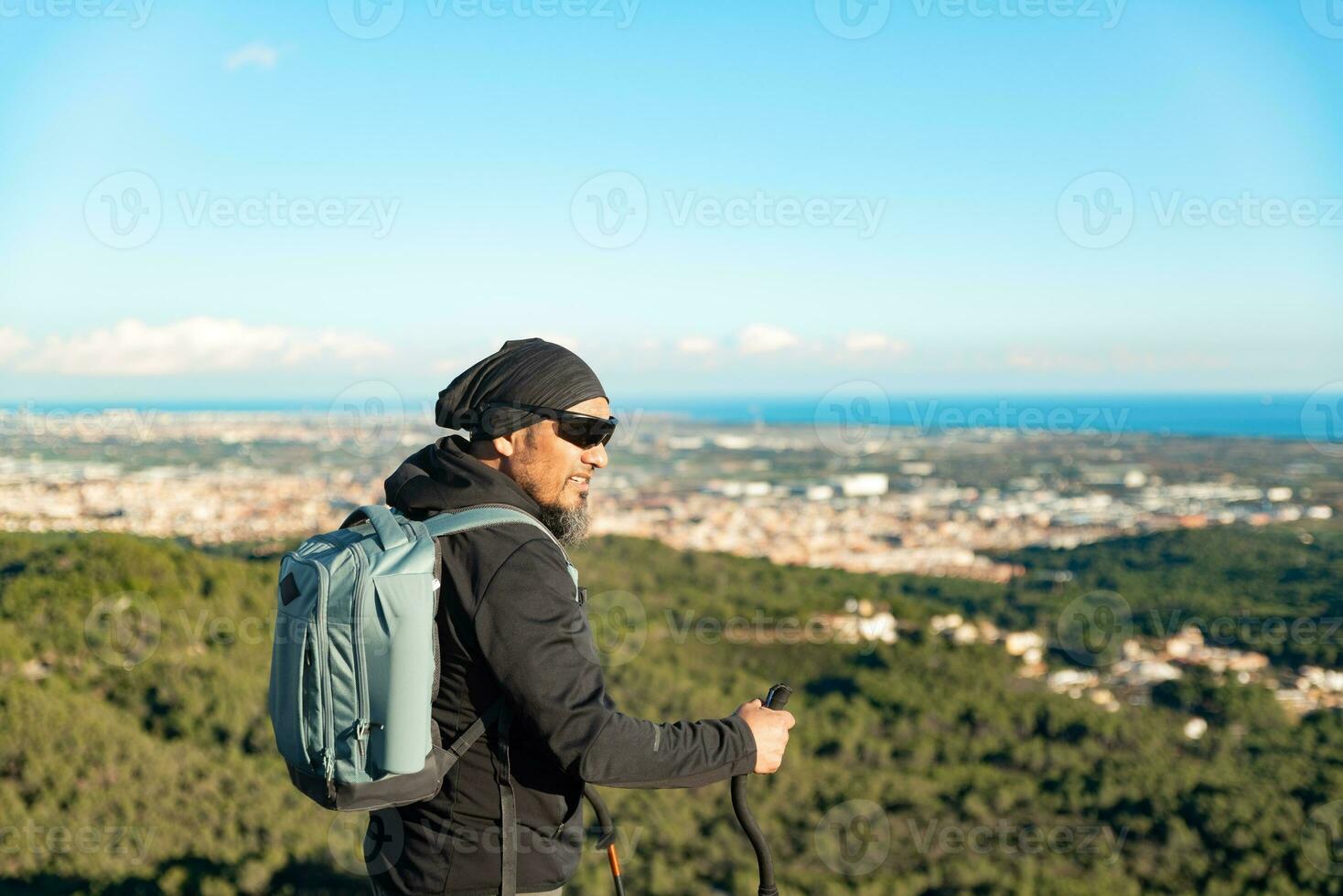 Middle-aged man contemplates the landscapes of the Garraf Natural Park while walking along the trails of a mountain. photo
