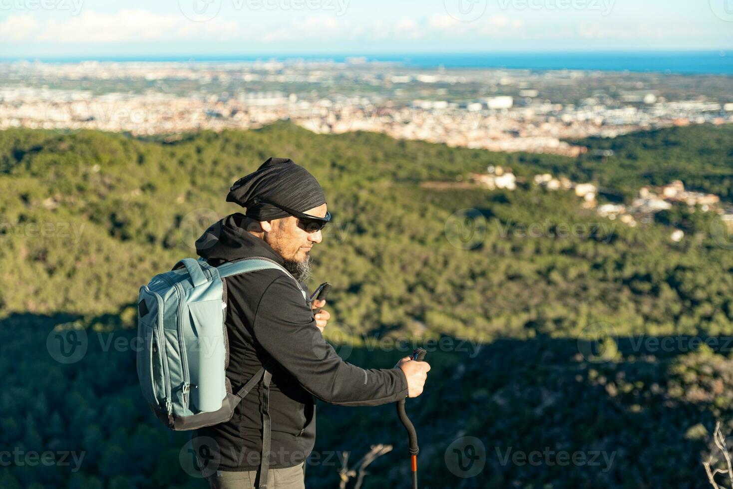 Middle-aged man contemplates the landscapes of the Garraf Natural Park while walking along the trails of a mountain. photo
