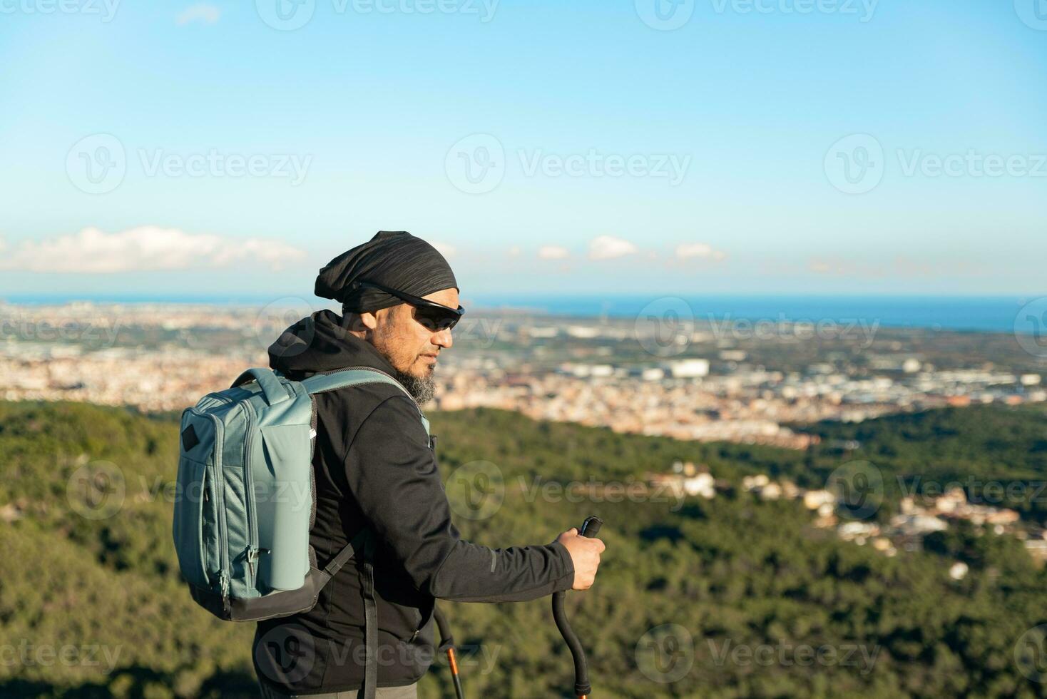 Middle-aged man contemplates the landscapes of the Garraf Natural Park while walking along the trails of a mountain. photo