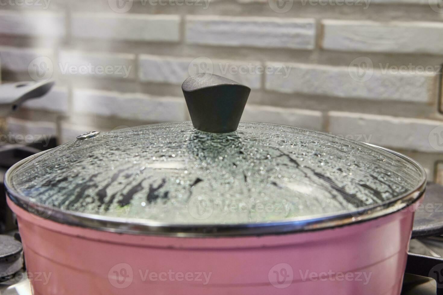 Close-up of Frying Pan Lid with Rising Steam and Water Droplets photo