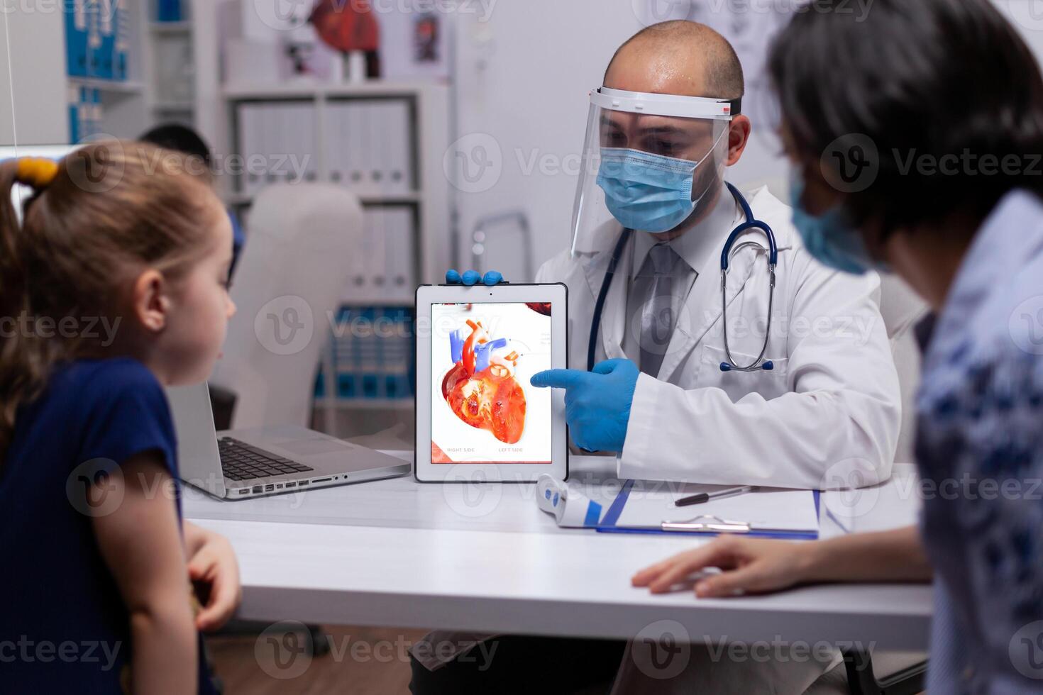 Pediatrician doctor holding digital tablet pc explaining heart condition in new normal medical clinic. Specialist physician talking about diagnostic resultes providing care services. photo