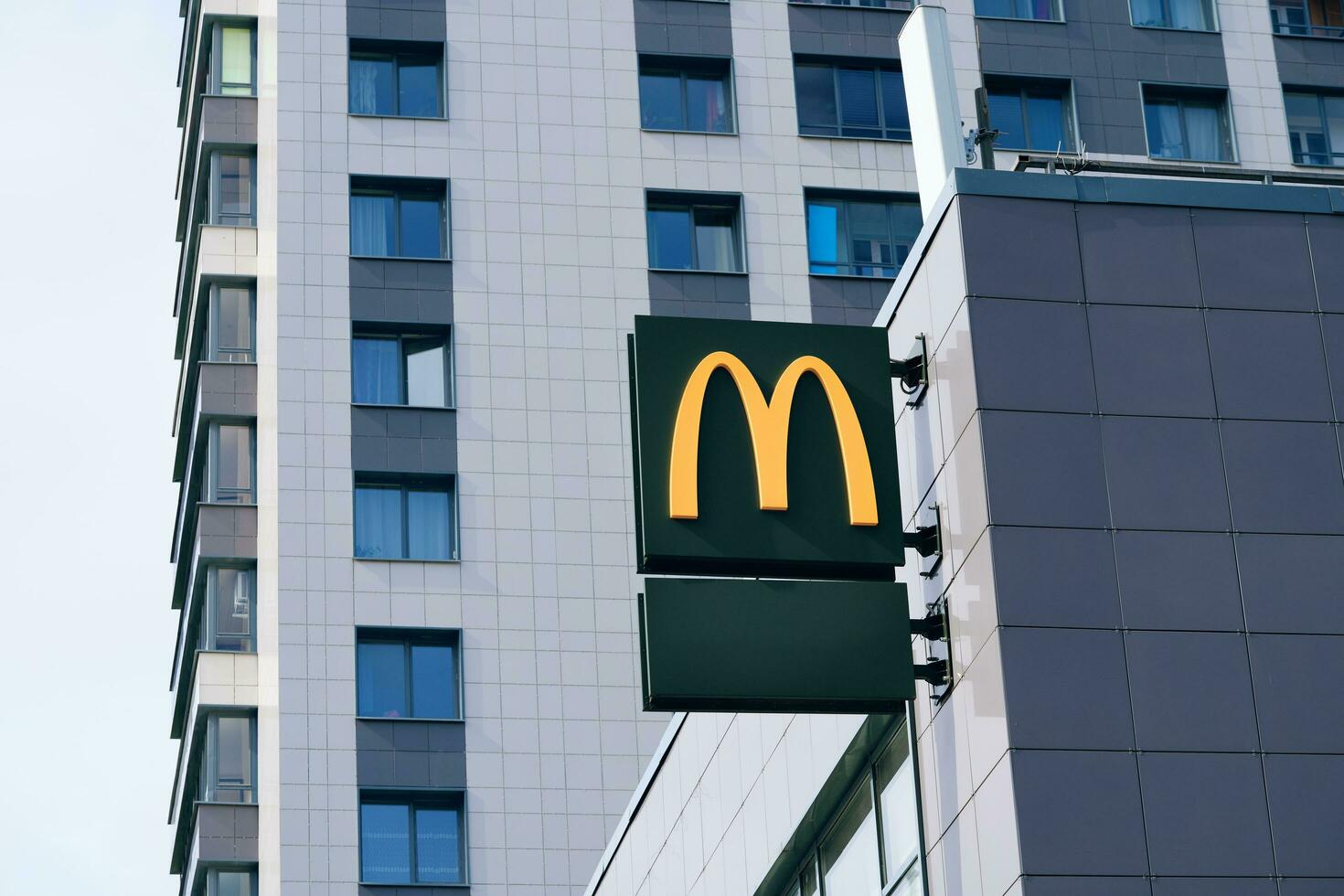 McDonalds logo of global cafe chain that specializes burgers men restaurant. Street sign of facade of fast food diner. Saint-Petersburg, Russia - August 31, 2021 photo