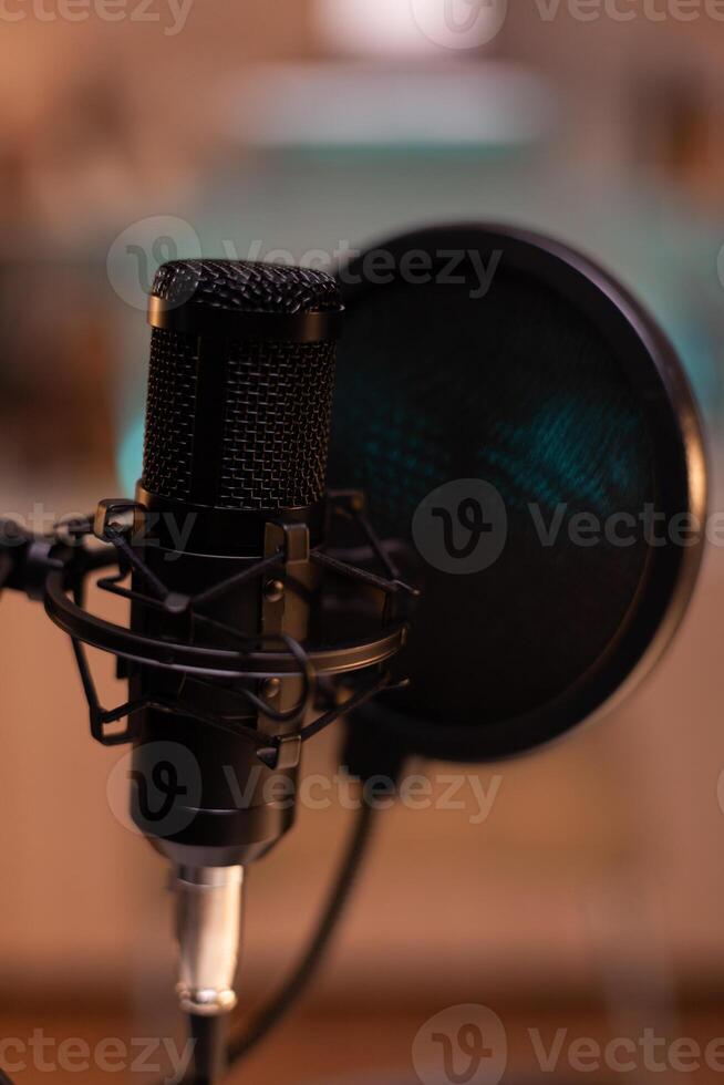 Zooming on professional microphone in vlogger home studio and neon light in the background. Influencer recording social media content with production microphone. Digital web internet streaming station photo