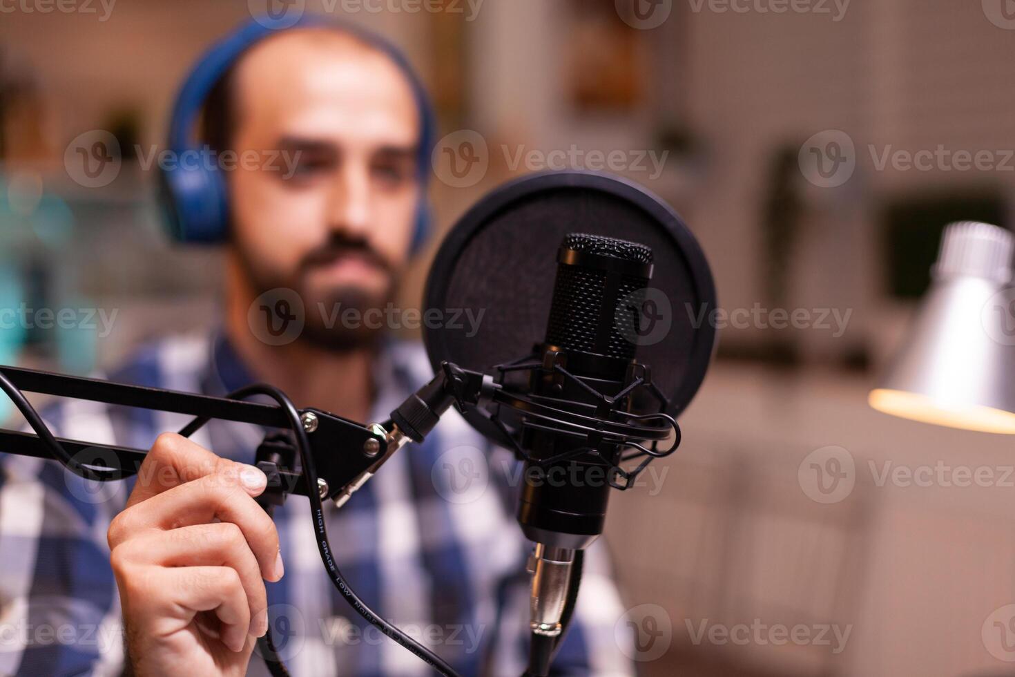 Blogger wearing headphones and talking about lifestyle during podcast Creative online show On-air production internet broadcast host streaming live content recording digital social media communication photo