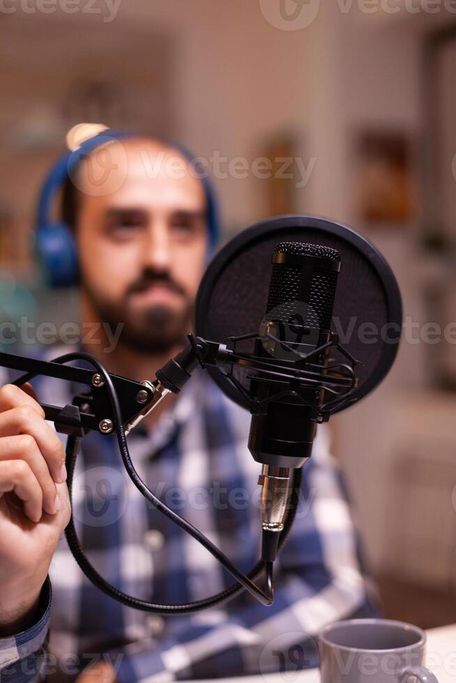 Close up of vlogger holding micophone while speaking during online interview. Online show On-air production internet broadcast host streaming live content, recording digital social media communication photo