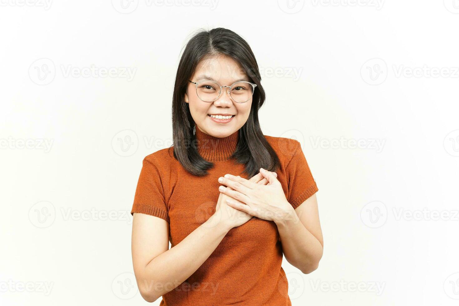 gesto agradecido y de amor propio de una hermosa mujer asiática aislada de fondo blanco foto