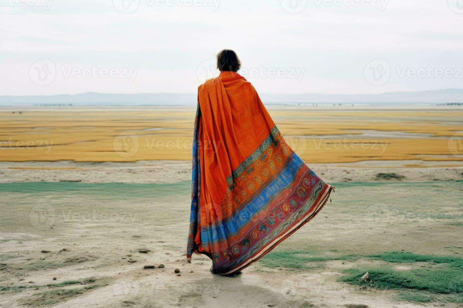 AI generated a beautiful moment of a woman dressed in an orange outfit, including a scarf, walking along the beach with a vibrant umbrella in her hand. photo