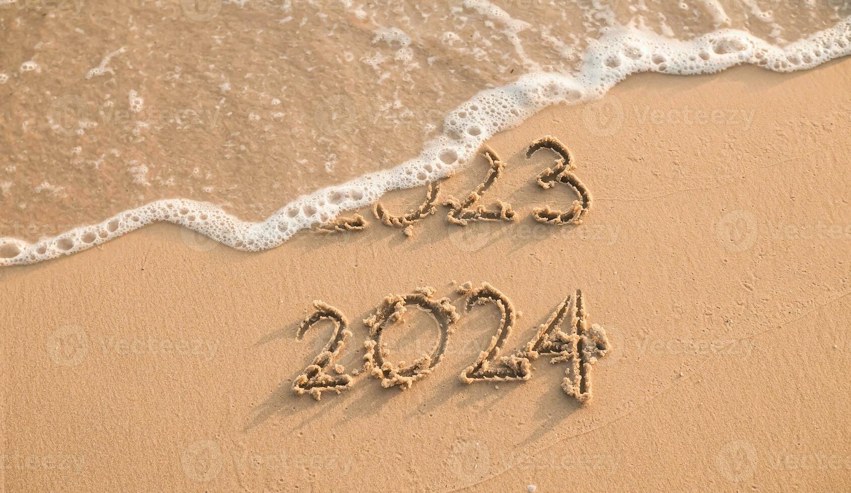 escrito inscripción 2023 y 2024 en el playa en el puesta de sol tiempo. el concepto de adiós 2023 y contento nuevo año 2024 foto