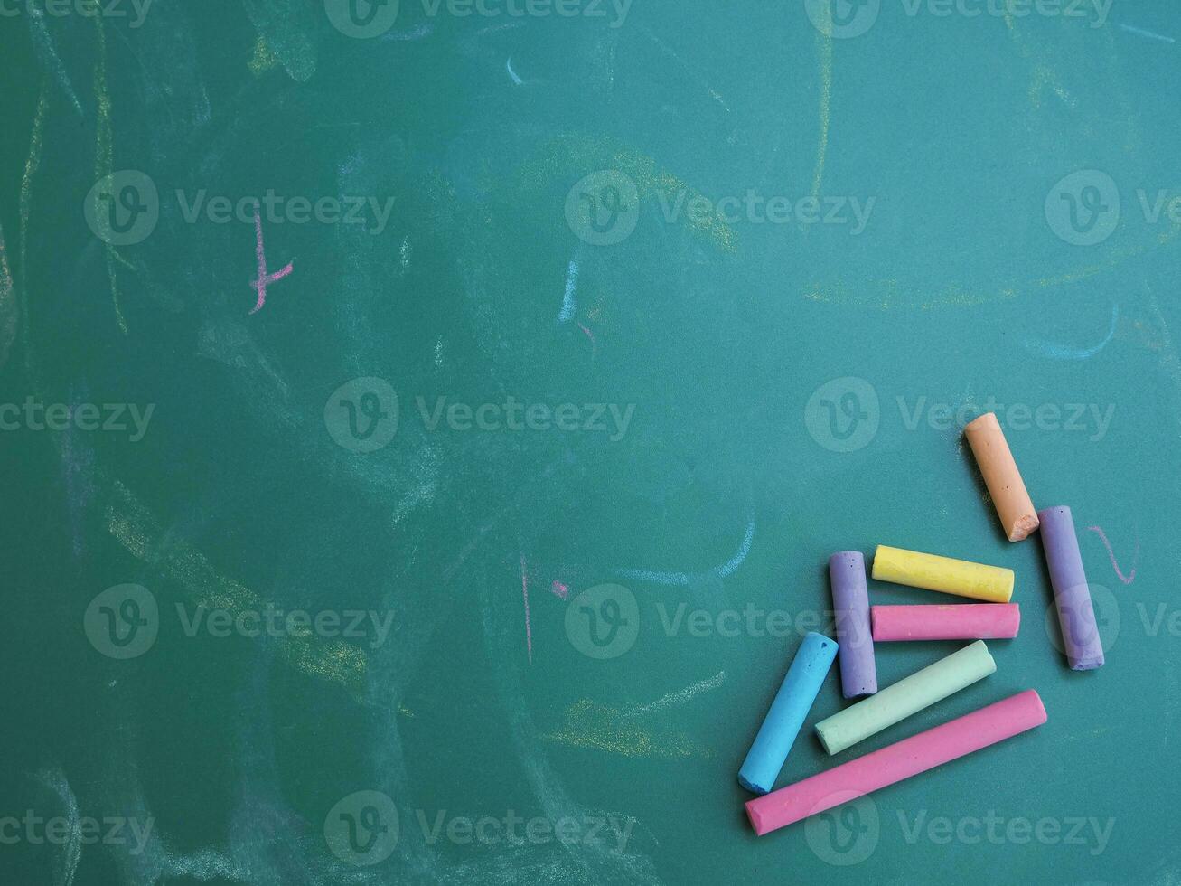 Multicolor chalks on chalkboard for education background photo