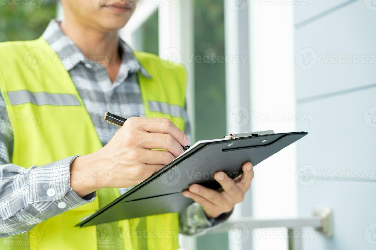 el inspector o ingeniero está inspeccionando la construcción y el aseguramiento de la calidad de la nueva casa usando una lista de verificación. ingenieros o arquitectos o contratistas trabajan para construir la casa antes de entregársela al propietario foto