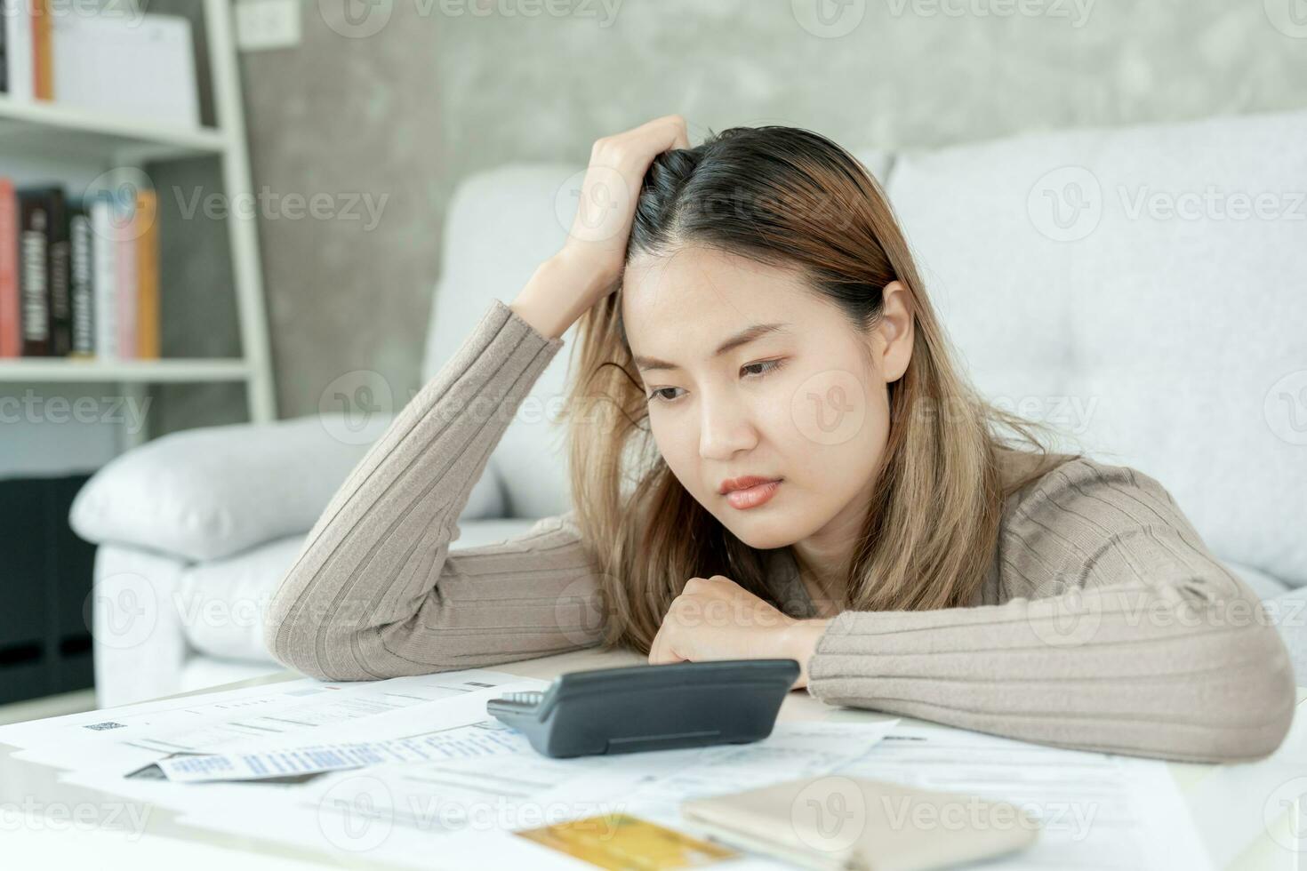 Stressed and headache asian woman with large bills or invoices no money to pay to expenses and credit card debt. shortage, Financial problems, mortgage, loan, bankruptcy, bankrupt, poor, empty wallet photo