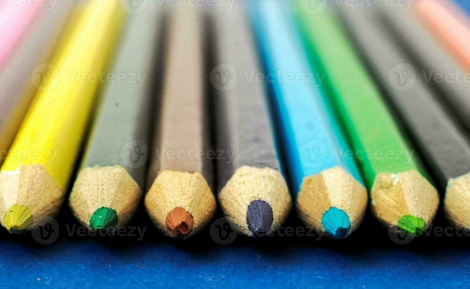 a row of colored pencils on a blue surface photo