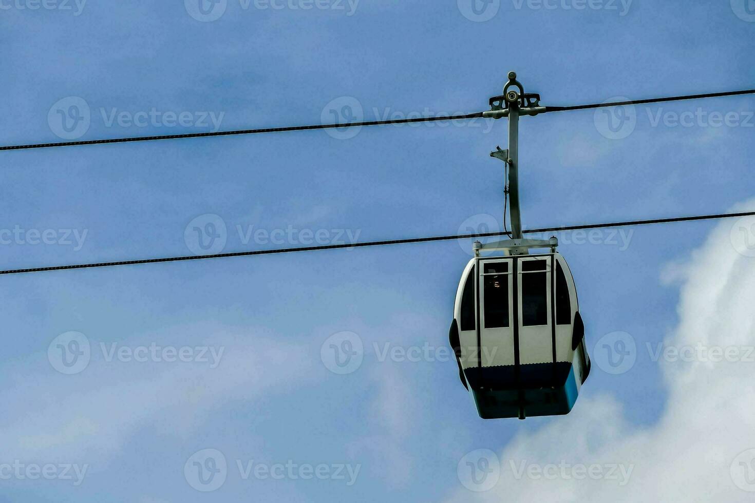 a cable car is suspended in the air with a blue sky photo