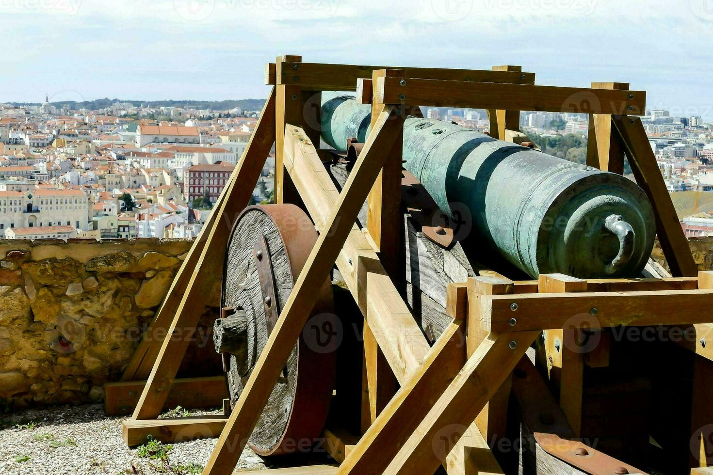 a cannon on top of a wooden platform overlooking a city photo