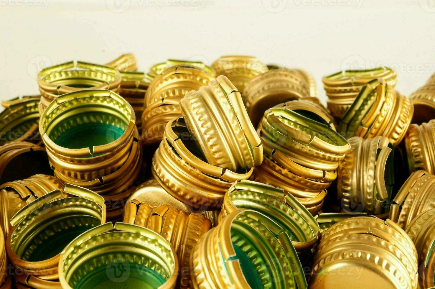 a pile of gold and green plastic bottle caps photo