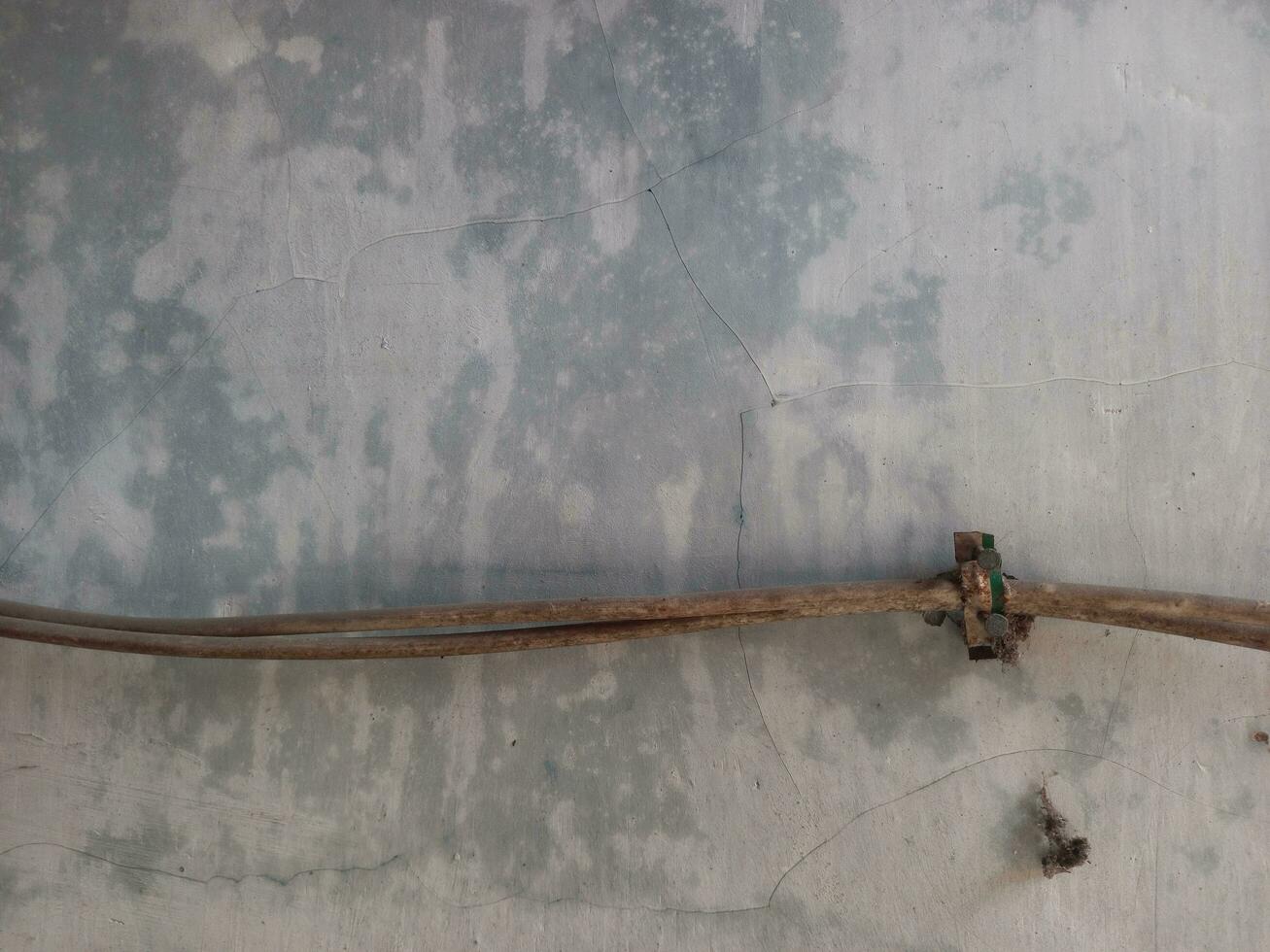 Old electric cable pinned on a wall. Grunge and weathered wall background. photo
