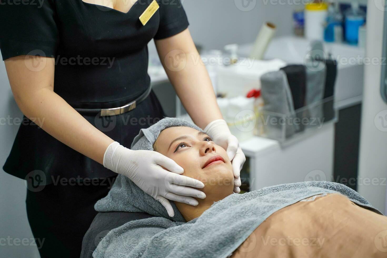 Closeup cosmetologists prepare customer's face before making facial massage with organic face scrub and smooth facial white mask cream photo