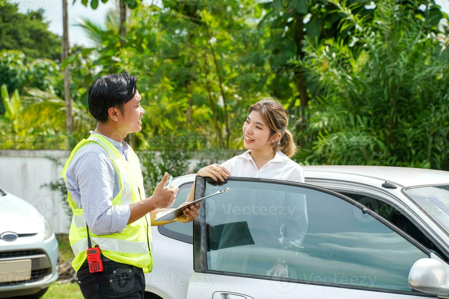 Closeup insurance agent with customer thumbs up is a sign of great work and hold a work list clipboard on outdoor background. photo