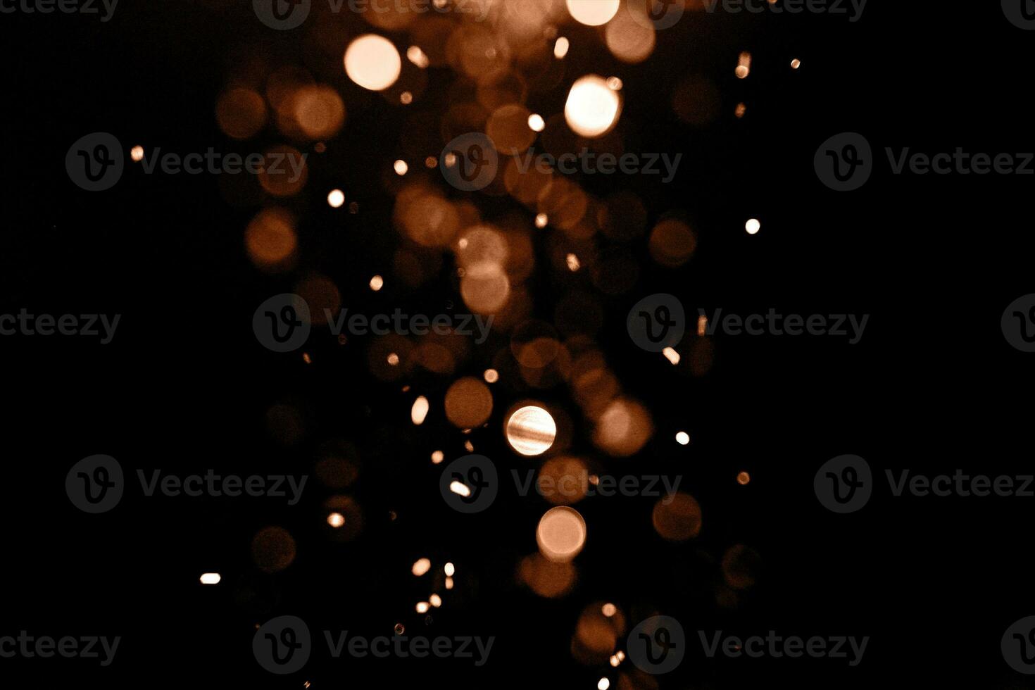 Blurry garland lights on a dark background. Festive Christmas and New Year background. Soft focus. Image toned in color of the year 2024 - Peach Fuzz photo