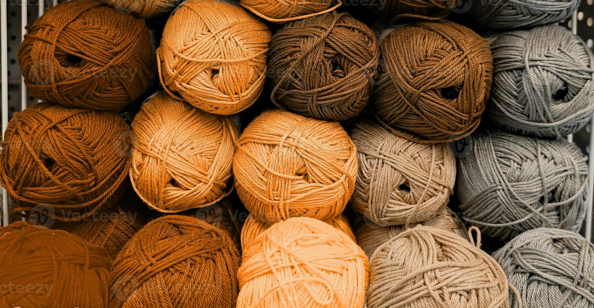 Colorful of Yarn Balls Wool in a Fabric Shop. Background from colored acrylic yarn. Skeins of thread close-up. Materials for needlework, for knitting and crocheting. Peach Fuzz colour of 2024 year photo