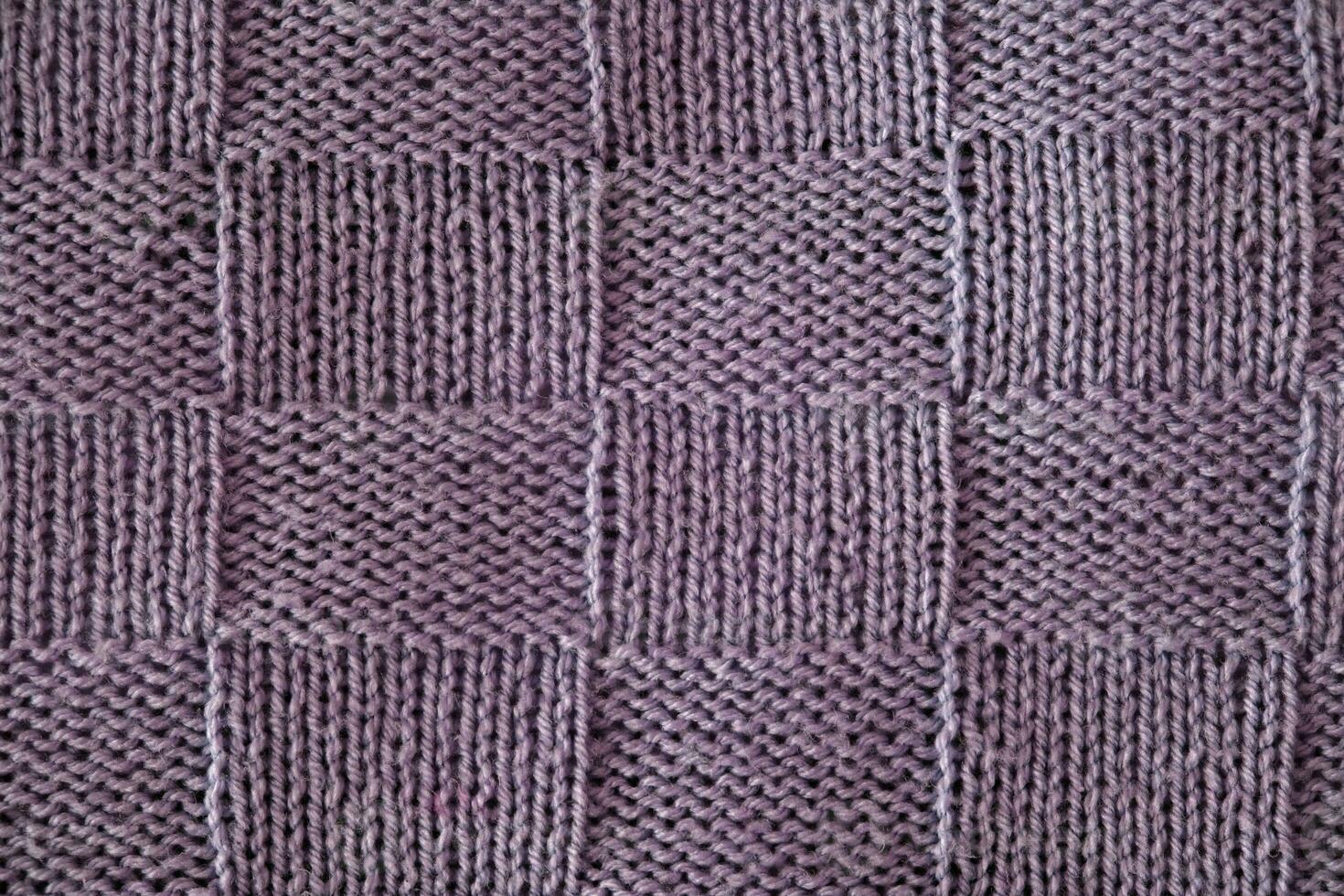 Unusual abstract knitted chess pattern background texture. Top view, close-up. Handmade knitting wool photo