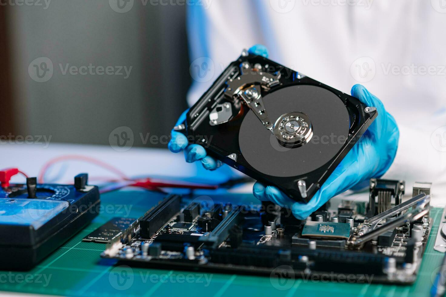 Hard disk drive on the technician's desk and a computer motherboard as a component. the concept of data, hardware, and information technology. photo