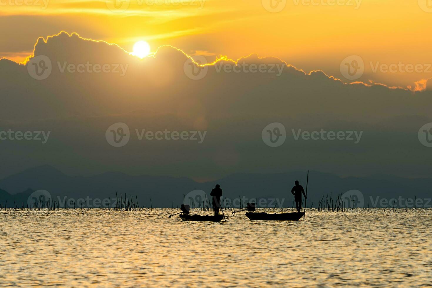Silhouette fisherman and Sunset sky on the lake. photo
