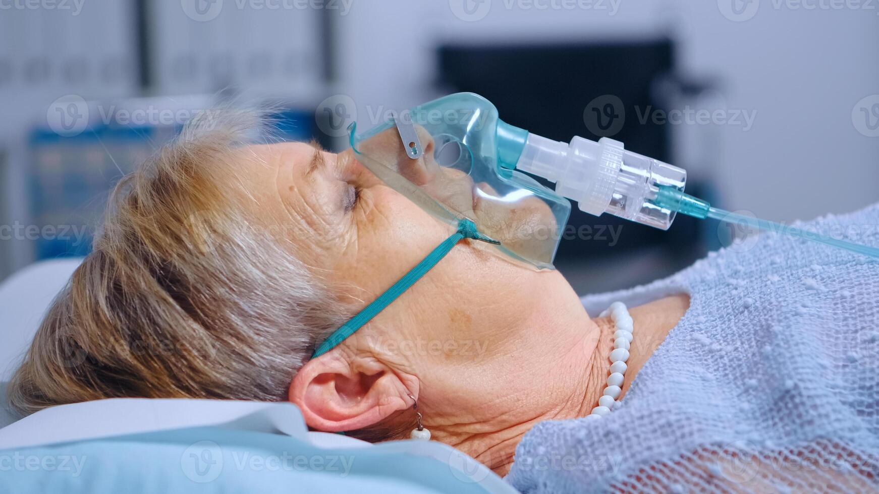 Close up portrait of retired woman breathing with difficulties in oxygen mask lying in hospital bed during covid-19 coronavirus outbreak. Medical medicine healthcare system. Infection treatment photo