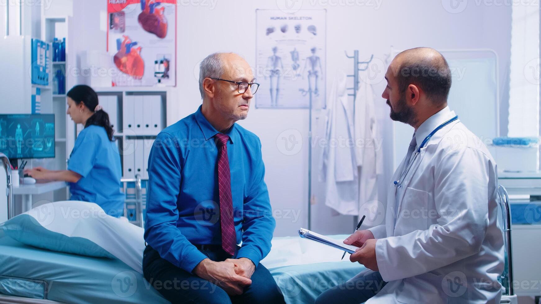 Old retired men in modern private clininc answering doctor questionnaire sitting on hospital bed. Ill aged patient seeking medical advice for disease prevention from general practitioner in modern private clinic, doctor diagnosis photo