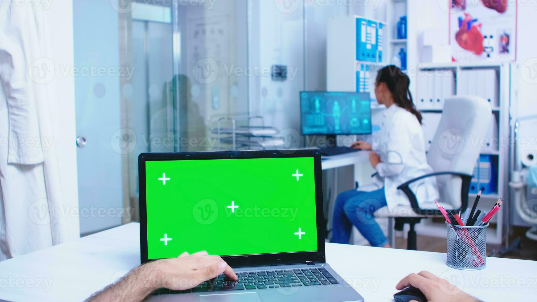 Pov laptop display with green mockup in hospital cabinet. Medical practitioner opening clinic glass door. Medic using notebook with chroma key on display in medical clinic. photo