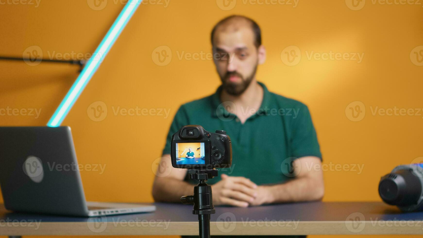 Cheerful content creator waving while recording podcast in home studio. Social media podcast and review, blogging vlogging, digital internet web era, influencer recording for online distribution photo