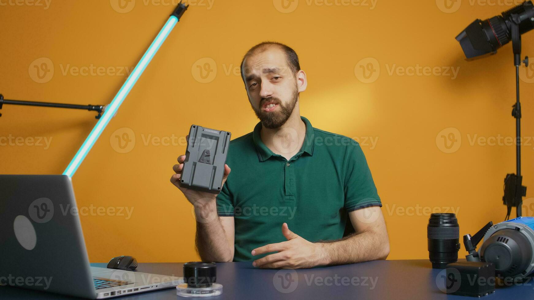 Content creator holding and recording v mount battery review for vlog. Professional acumulator. Modern V-Lock type technology, social media star influencer online distribution photo