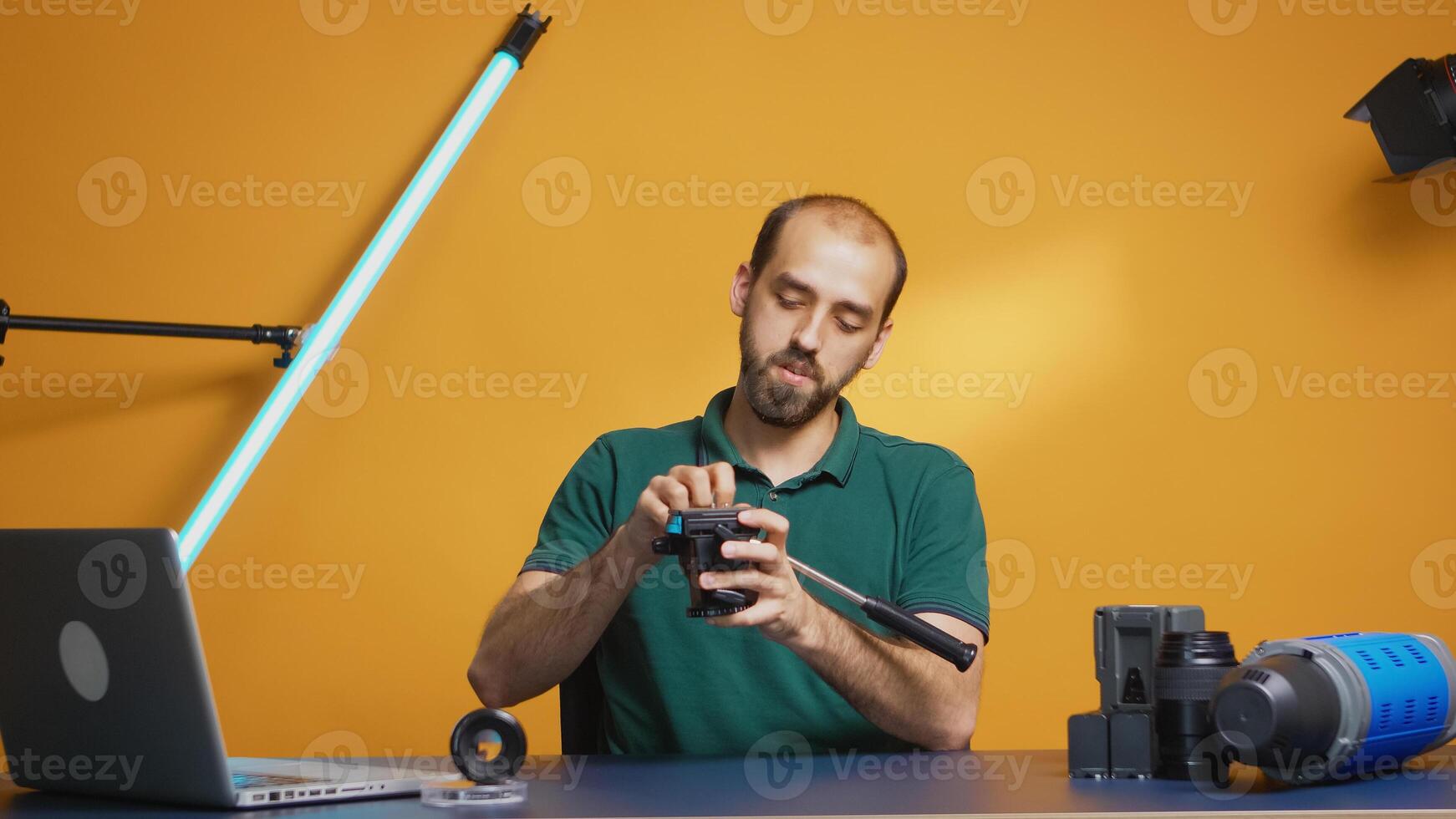 Videographer recording tutorial about tripod head with fluid head. Professional studio video and photo equipment technology for work, photo studio social media star and influencer