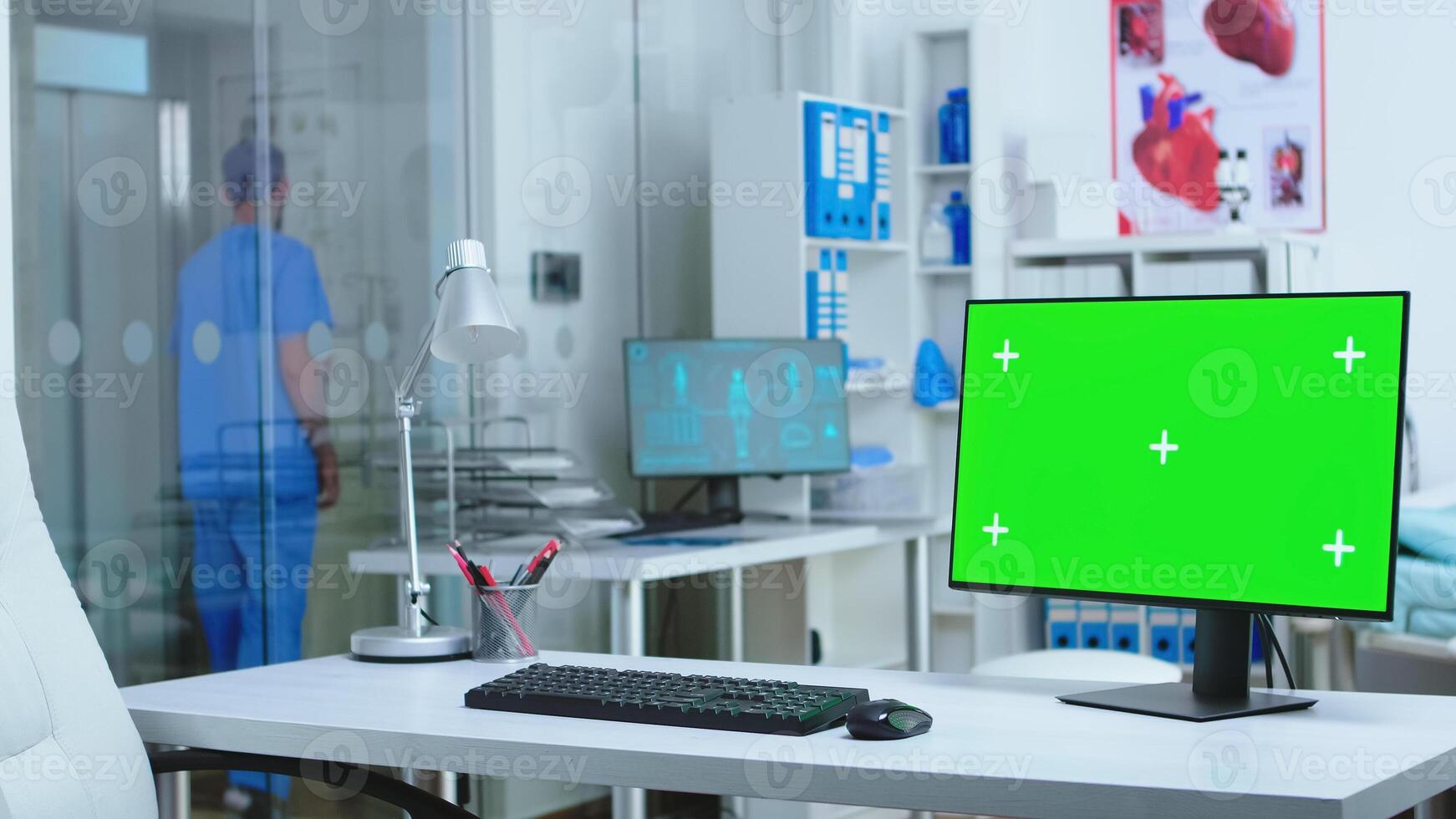 Monitor with green screen in hospital while male assistant waiting elevator. Computer with blank space available on medicine specialist in clinic cabinet. photo
