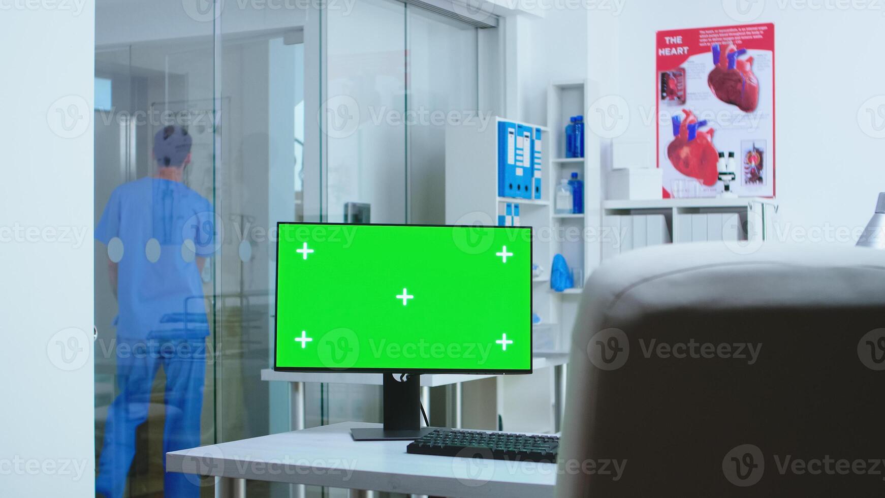 Computer with copy space available in hospital and assistant going in elevator. Desktop with blank green screen mockup isolated space available on of medicine specialist in clinic cabinet. photo