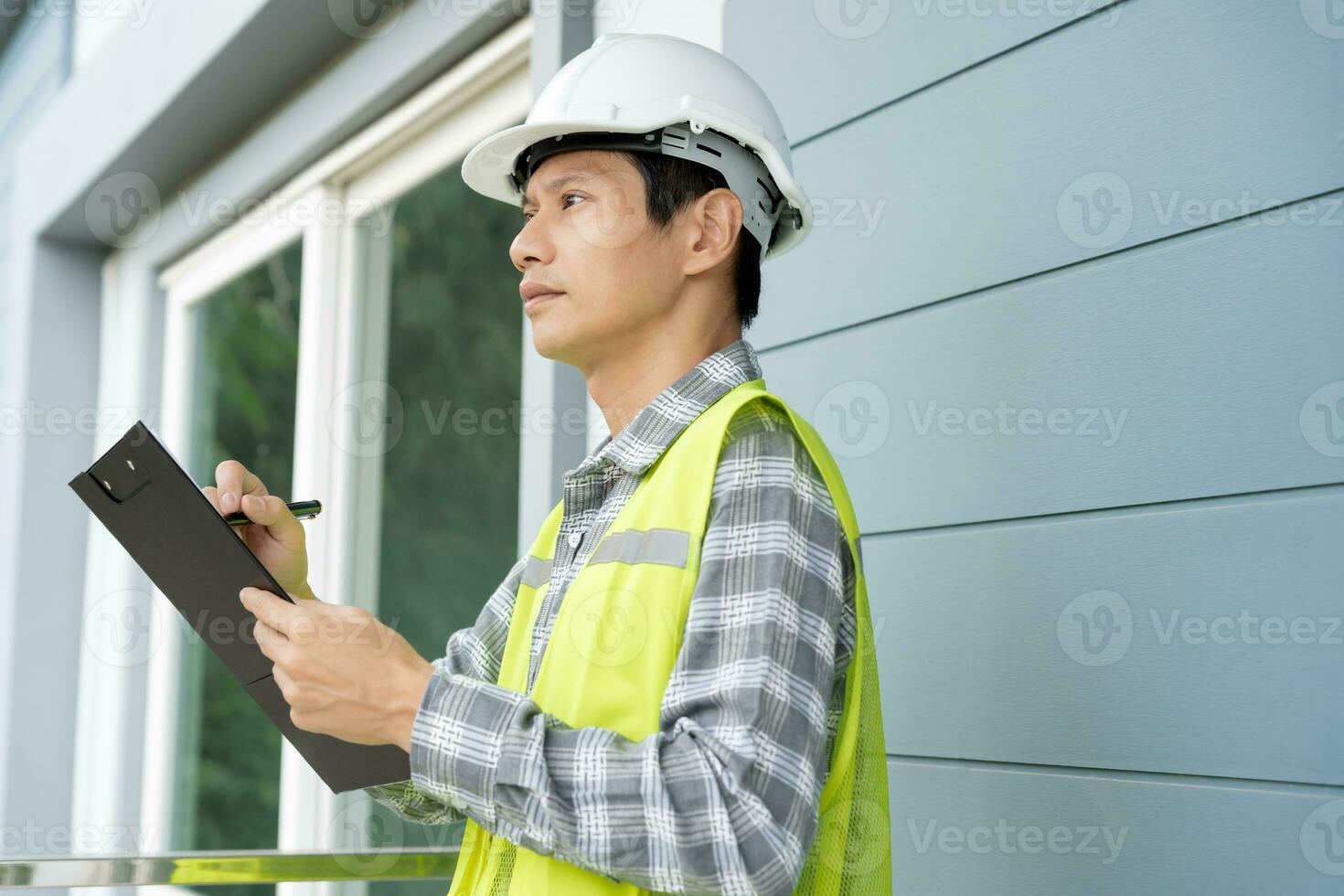 inspector or engineer is inspecting construction and quality assurance new house using a checklist. Engineers or architects or contactor work to build the house before handing it over to the homeowner photo