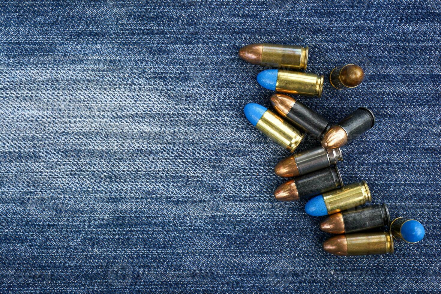 colorful gun bullets on jeans background . soft and selective focus. photo