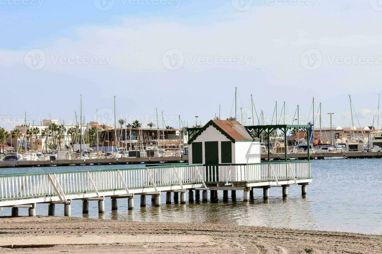 un muelle con un pequeño casa en eso en frente de barcos foto