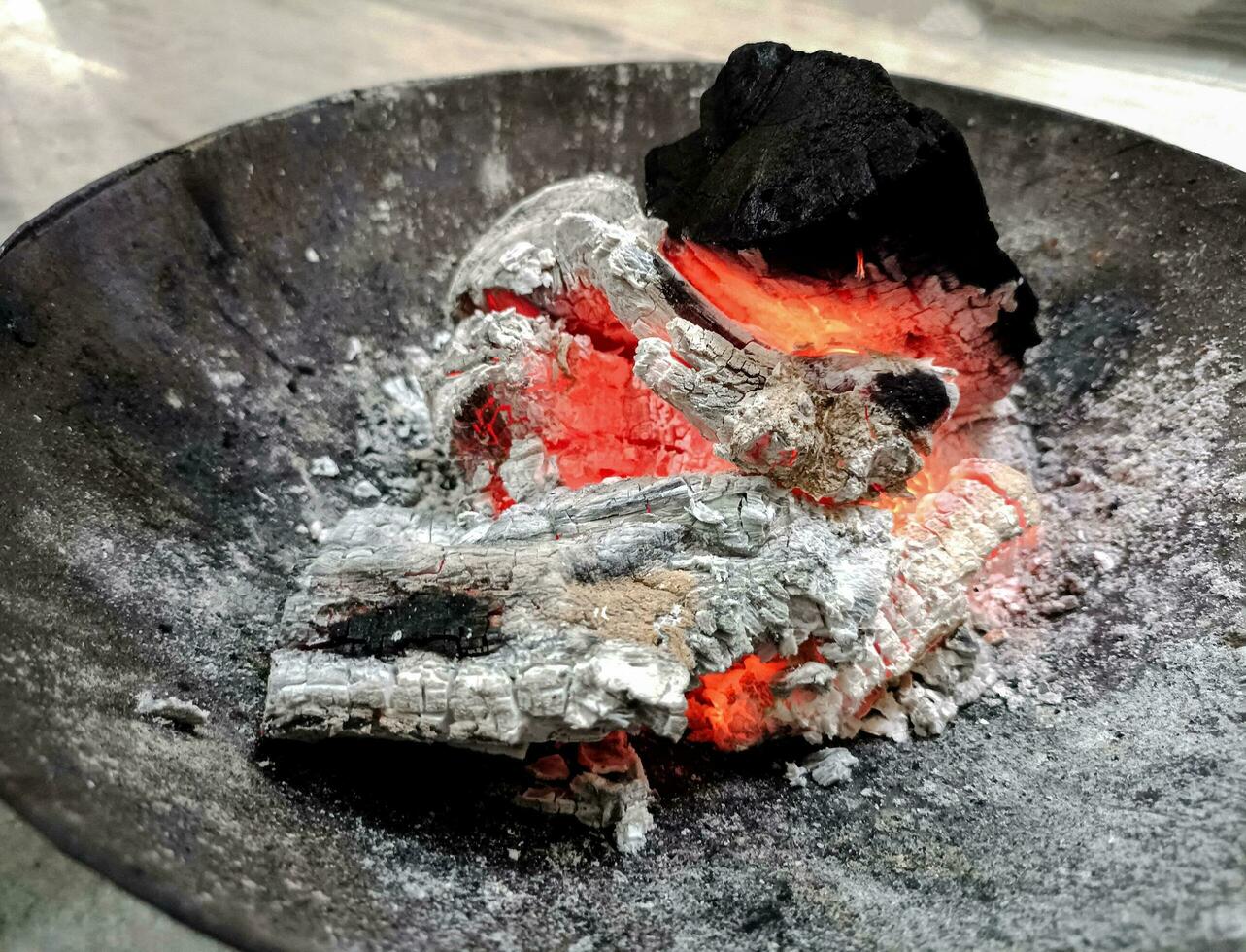 Logs burn in the campfire. Close-up of firewood, coals photo