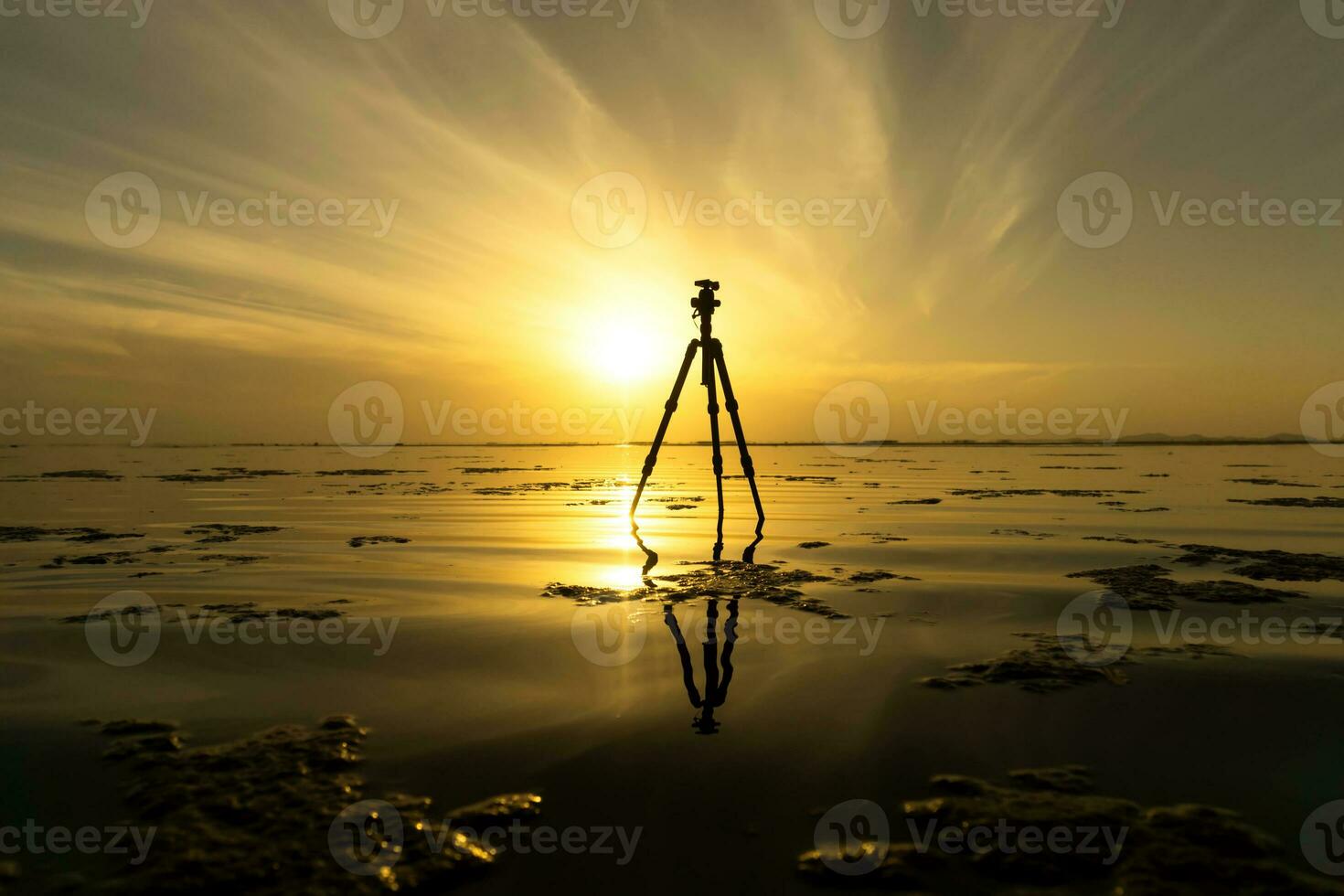 Tripod on the lake with sunrise sky. photo